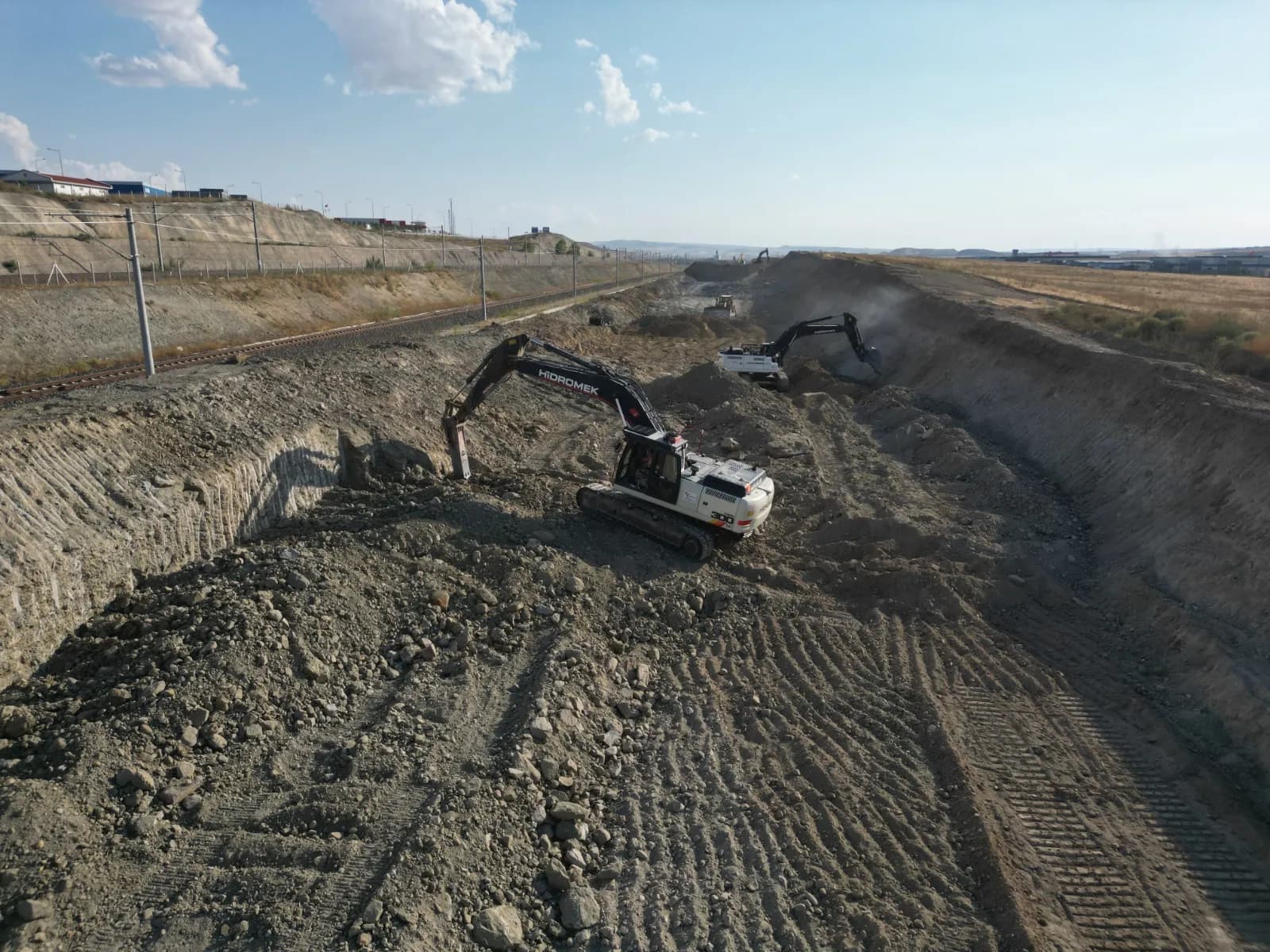 Kırıcılı ekskavatörle kayalık zeminde kazı, drone görüntüsü